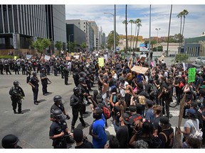 Protestors gather in front of a row of LAPD officers during a demonstration over the death of George Floyd in Hollywood, California on June 2, 2020. - Anti-racism protests have put several U.S. cities under curfew to suppress rioting, following the death of George Floyd in police custody.