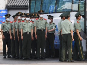 Chinese paramilitary police prepare to guard entrances to the closed Xinfadi market in Beijing on June 13, 2020.