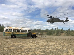 An Alaska National Guard helicopter hovers near "Bus 142" after it was deposted on the ground west of Healy, Alaska, June 18, 2020.