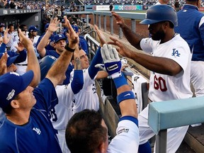 Dodger's Andrew Toles (right) celebrates with teammates after scoring on a single by Chase Utley during Game 4 of the National League Division Series against the Nationals at Dodger Stadium, in Los Angeles, Oct. 11, 2016.