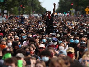 A man holds up his fist while hundreds of demonstrators march to protest against police brutality and the death of George Floyd, on June 2, 2020, in Washington, DC.