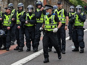 A substantial police presence watches over activists who have gathered in George Square to protect it from any vandalism attacks in Glasgow, Scotland, June 14, 2020. The Loyalist Defence League has asked followers to gather in George Square over the weekend for a 'protect the Cenotaph' event in response to statues being defaced across Scotland following BLM demonstrations.