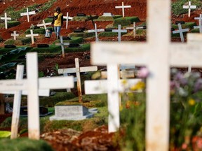 A worker carries a bucket while maintaining graves at the Christian burial area provided by the government for victims of the coronavirus disease (COVID-19) at Pondok Ranggon cemetery complex in Jakarta, Indonesia, June 27, 2020.