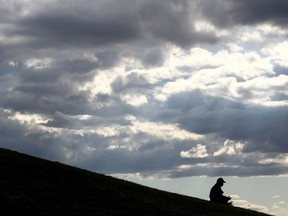 Files: A man sits in a park on a cloudy day