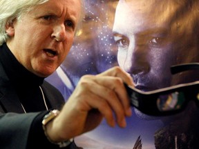 Canadian director James Cameron shows 3D glasses as he poses in front of a poster before a promotion event for his movie Avatar at the World Economic Forum, in Davos, Switzerland, Jan. 28, 2010.