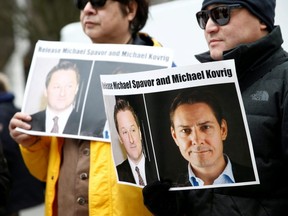 People hold signs calling for China to release Canadian detainees Michael Spavor and Michael Kovrig during an extradition hearing for Huawei Technologies Chief Financial Officer Meng Wanzhou at the B.C. Supreme Court in Vancouver, March 6, 2019.