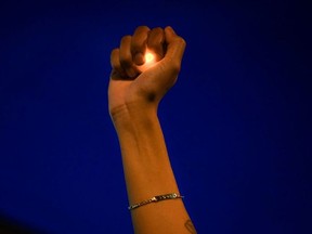 A woman holds an electric candle in her hand at a rally against racial inequality and the police shooting death of Rayshard Brooks, in Atlanta, Georgia, U.S. June 17, 2020.