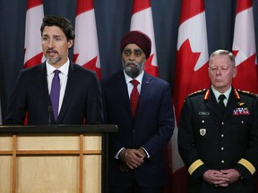 Minister of National Denfence Harjit Sajjan (centre) and Chief of Defence Staff General Jonathan Vance (right) listen as Canadian Prime Minister Justin Trudeau (left) speaks during a news conference January 9, 2020 in Ottawa, Canada.