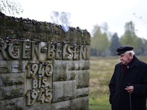 A man stands in front of a memorial plaque during a ceremony to commemorate the 70th anniversary of the liberation of the Bergen-Belsen concentration camp at the former camp site on April 26, 2015 near Lohheide, Germany.