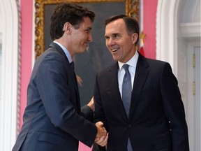 (FILES) In this file photo taken on Nov. 20, 2019, Canadian Prime Minister Justin Trudeau shakes hands with Minister of Finance Bill Morneau during a ceremony at Rideau Hall.
