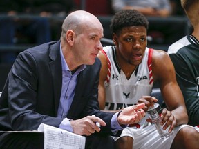 Former head coach Dave Smart chats with Alain Louis on the bench as the Carleton Ravens take on the Calgary Dinos during the quarter finals of the 2020 U SPORTS Final 8 Championships at TD Place in Ottawa.