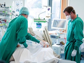 Swiss army soldier Julien (right) helps a medical worker to treat a patient in the intensive care unit of a hospital during the COVID-19 outbreak in Payerne, Switzerland, April 6, 2020.