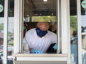 Ontario Premier Doug Ford stands at a window used for take-outs as he visits a bakery in Toronto, on Friday, July 10, 2020. THE CANADIAN PRESS/Chris Young ORG XMIT: chy104