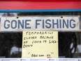 A sign reading "Gone Fishing" is pictured on the window of a closed barber shop in Santa Monica, Calif., Tuesday, July 28, 2020.