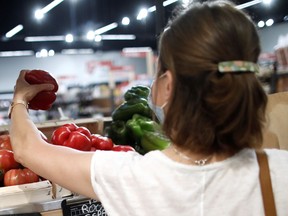 A masked customer shops for vegetables.