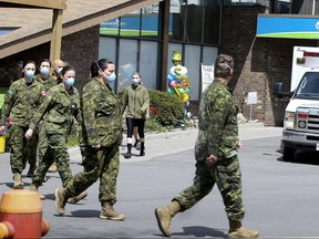 Members of the Canadian Armed Forces walk in front of Pickering's Orchard Villa long-term care home on Wednesday, May 6, 2020.