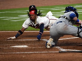 Atlanta Braves' Ronald Acuna Jr. dives into home safely against Toronto Blue Jays catcher Danny Jansen during Tuesday's game.