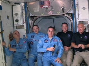 In this screen grab from NASA's feed, NASA astronauts Doug Hurley (right) and Bob Behnken (second from right) join NASA astronaut Chris Cassidy (centre) and Russian cosmonauts, Anatoly Ivanishin (left) and Ivan Vagner (second from left) aboard the International Space Station after successfully docking SpaceX's Dragon capsule May 31, 2020.