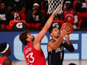 Nikola Vucevic of the Orlando Magic goes up for a shot against Marc Gasol of the Toronto Raptors in the first half at Visa Athletic Center at ESPN Wide World Of Sports Complex on August 5, 2020 in Lake Buena Vista, Fla.