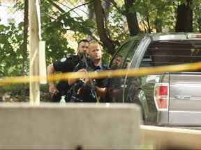 Toronto Police officers contain an area behind a low-rise apartment complex at 3673 Shoreham Dr. on Aug. 2, 2020.