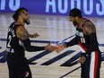 Carmelo Anthony, right, and CJ McCollum of the Portland Trail Blazers celebrate a three point basket against the Memphis Grizzlies during the fourth quarter in the Western Conference play-in game one at The Field House.