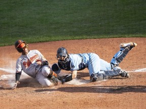 Orioles centre fielder Mason Williams is tagged out by Blue Jays catcher Danny Jansen during the 10th inning at Sahlen Field in Buffalo, N.Y. on monday.