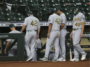 Oakland Athletics players walk off the field before a game against the Houston Astros at Minute Maid Park on Friday, Aug. 28, 2020.