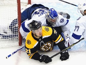 Tampa Bay Lightning goaltender Andrei Vasilevskiy lands on top of Nick Ritchie of the Boston Bruins during Eastern Conference round robin play on Wednesday.