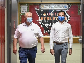 Ontario Premier Doug Ford, left, and Education Minister Stephen Lecce walk a school hallway.