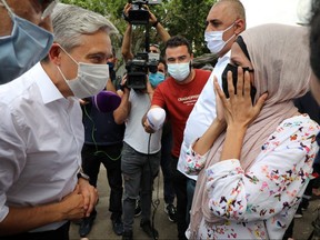A woman affected by the massive blast in Beirut's port area reacts as she meets with Canadian Foreign Minister Francois-Philippe Champagne, at World Food Program distribution site in Beirut, Lebanon, Thursday, Aug. 27, 2020.