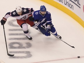 Tampa Bay Lightning right wing Nikita Kucherov (86) skates with the puck away from Columbus Blue Jackets center Gustav Nyquist (14) during the first period in game two of the first round of the 2020 Stanley Cup Playoffs at Scotiabank Arena.