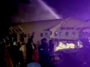 A passenger plane that crashed after it overshot the runway is seen at Calicut International Airport in Karipur, southern state of Kerala, India, August 7, 2020, in this still image obtained from a video.