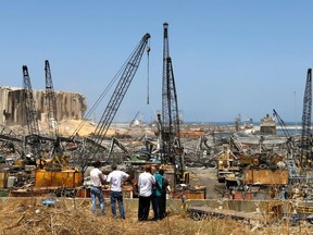 Men look at the site of Tuesday's blast in Beirut's port area, Lebanon August 8, 2020.