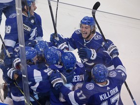 Tampa Bay Lightning players celebrate Brayden Point’s game-winning goal against the Columbus Blue Jackets in the fifth overtime of the opening game of their Eastern Conference playoff series on Tuesday.