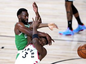 Boston Celtics’ Kemba Walker, and Toronto Raptors’ OG Anunoby compete for the ball last night in Lake Buena Vista, Fla. AP