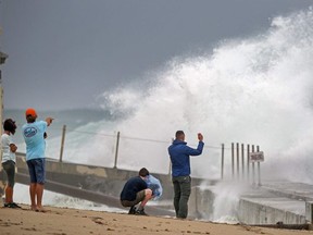 Waves driven by Tropical Storm Isaias crash over the jetty on the north side of the Palm Beach Inlet in Palm Beach Shores Sunday, Aug. 2, 2020.