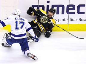 Bruins captain Zdeno Chara is hit into the boards by Alex Killorn of the Lightning.