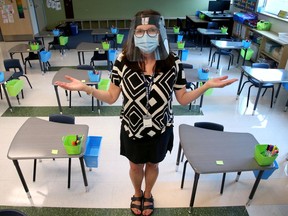 Grade one teacher Lynda Caron shows off the new arrangement of desks in her classroom. École Maurice-Lapointe in Kanata (which has Jr. Kindergarten through high school classes) opens to returning students Thursday.