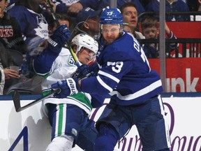 Canucks forward Tyler Toffoli, left, gets hammered by Leafs forward Kyle Clifford, right, during NHL action at Scotiabank Arena in Toronto, Feb. 29, 2020.