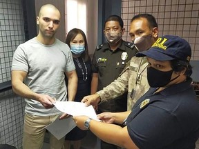 This handout photo taken on September 11, 2020 and released by the Bureau of Corrections (BUCOR) shows US marine Lance corporal Joseph Scott Pemberton (L), who was convicted of killing a transgender woman and recently pardoned by Philippine President Rodrigo Duterte, poses for a photo during a turnover from the Bureau of Corrections to Bureau of Immigration at a cell inside the military headquarters compound in Manila.