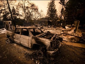 A burned vehicle is seen next next to a house reduced to ashes by the Glass Fire in Napa Valley, Calif, Monday, Sept. 28, 2020.