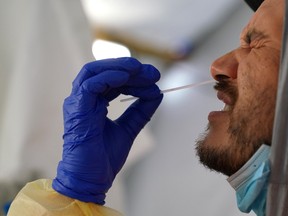 Ontario health workers perform COVID-19 nasal swab tests on a man of the remote First Nation community of Gull Bay, Ont., April 27, 2020.