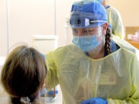 Kellie Ross, a registered practical nurse at Cassellholme Home for the Aged in North Bay, Ont., performs a COVID-19 swab on a staff member.