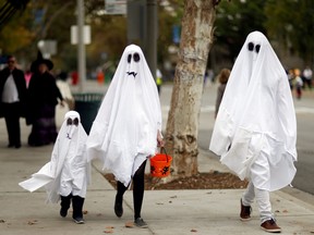 FILES: People wearing costumes walk during Halloween i