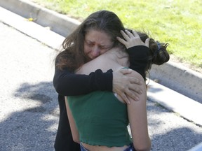 A mother and daughter break down out front of a house Parklane Ave. in Oshawa where five family members were shot to death, including the gunman, on Friday, Sept. 4, 2020.