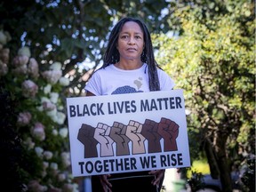 Wendy Knight Agard stands beside the Black Lives Matter sign outside her home in Stittsville on Saturday.