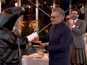 This handout picture released courtesy of Image Group LA / American Broadcasting Companies, Inc. / ABC shows host Canadian actor Eugene Levy receiving his Emmy while his son actor/director/writer Daniel Levy watches during the 72nd Primetime Emmy Awards ceremony held virtually on September 20, 2020.