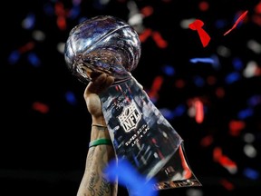 A detail of a New England Patriots player raising the Vince Lombardi Trophy after the Patriots defeat the Los Angeles Rams 13-3 during Super Bowl LIII at Mercedes-Benz Stadium on February 3, 2019 in Atlanta, Georgia.