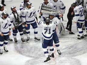 Athony Cirelli #71 of the Tampa Bay Lightning hands off the Stanley Cup to Mikhail Sergachev #98 following the series-winning victory over the Dallas Stars in Game Six of the 2020 NHL Stanley Cup Final at Rogers Place on September 28, 2020 in Edmonton, Alberta