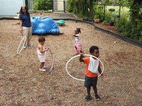 OTTAWA- June 11, 2020 --Pius (orange sweater), Gabriella (pink shorts) and Jaeda (white shorts) play as Veena Aithal (L), educator, looks on at the Andrew Fleck Child Care Centre on Queen Mary St. in Ottawa, June 11, 2020. Photo by Jean Levac/Postmedia News assignment 134012  Covid